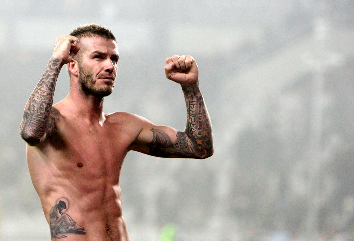 Footballer David Beckham celebrates at the end of a match  at Olympic stadium in Turin. Don’t miss the hindi&nbsp;‘Victoria’ tattoo on his left wrist! Other than that Beckham has 32 other tattoos. (Photo: Reuters)