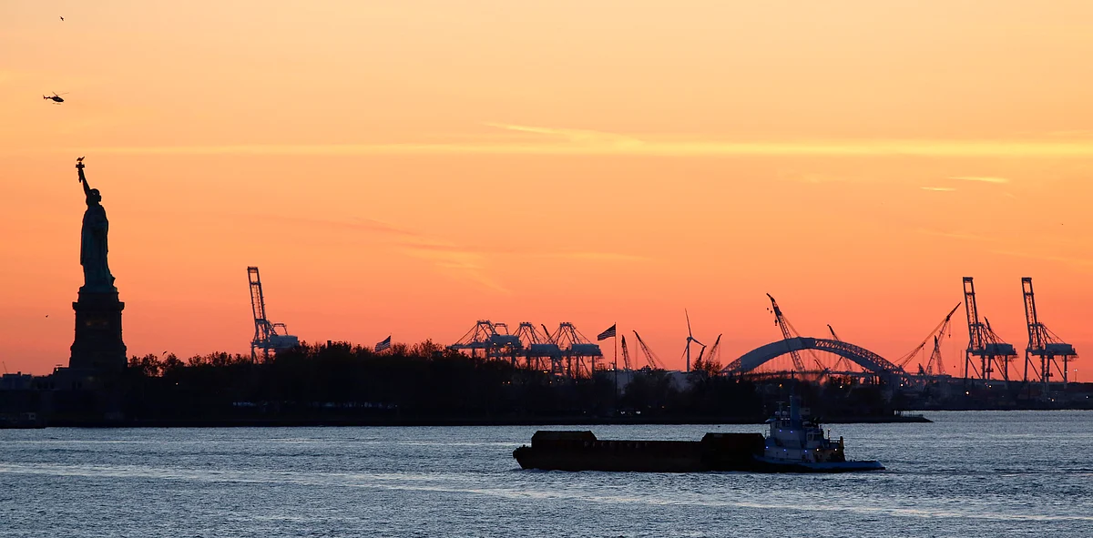 A barge passes near the Statue of Liberty at sunset in New York. (Photo: Reuters)