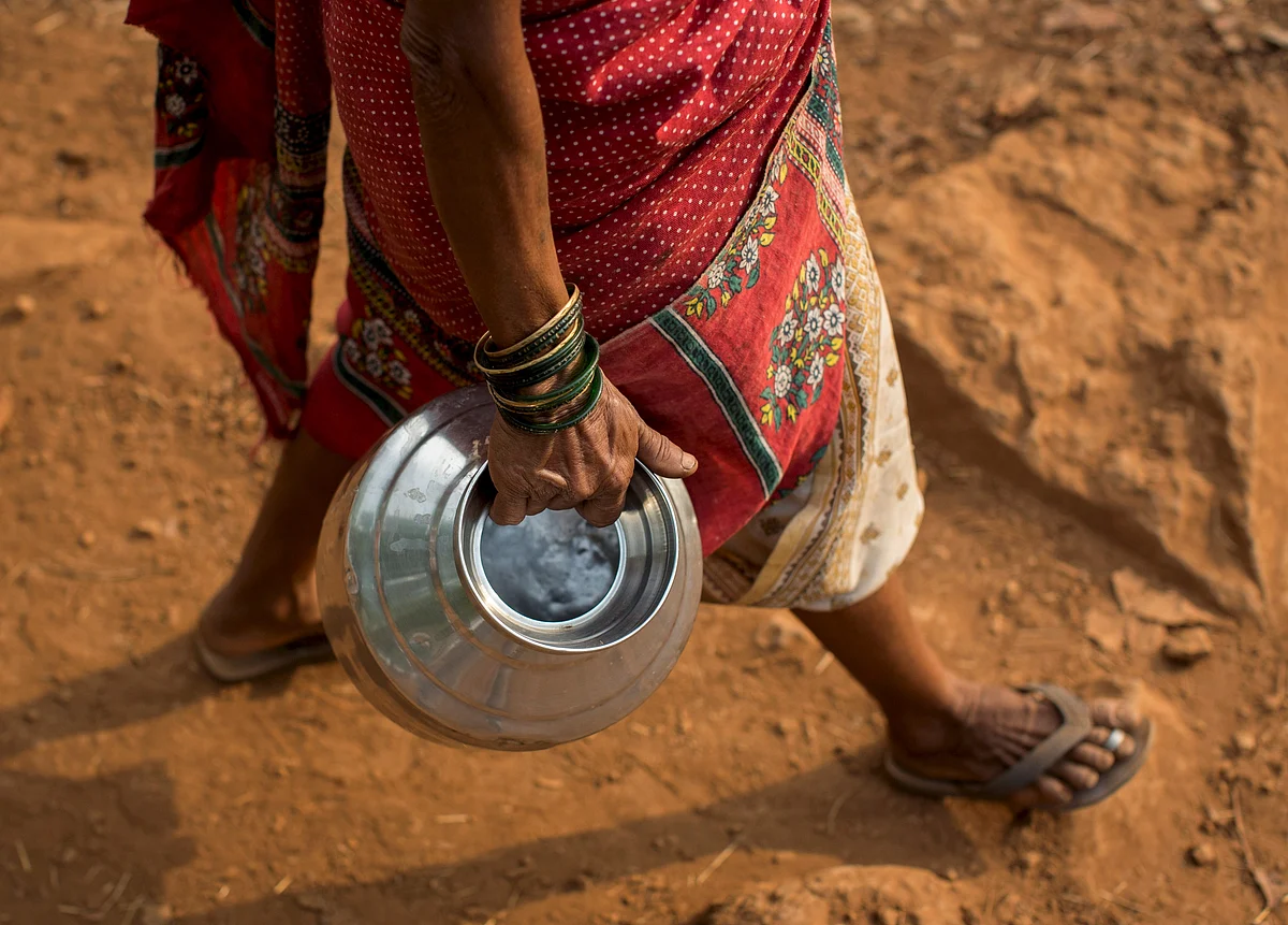 Sakhri, second wife of Sakharam Bhagat, carries an empty metal pitcher as she walks to fetch water from a well outside her village in Denganmal, Maharashtra, India, April 20, 2015. (Photo: Reuters)