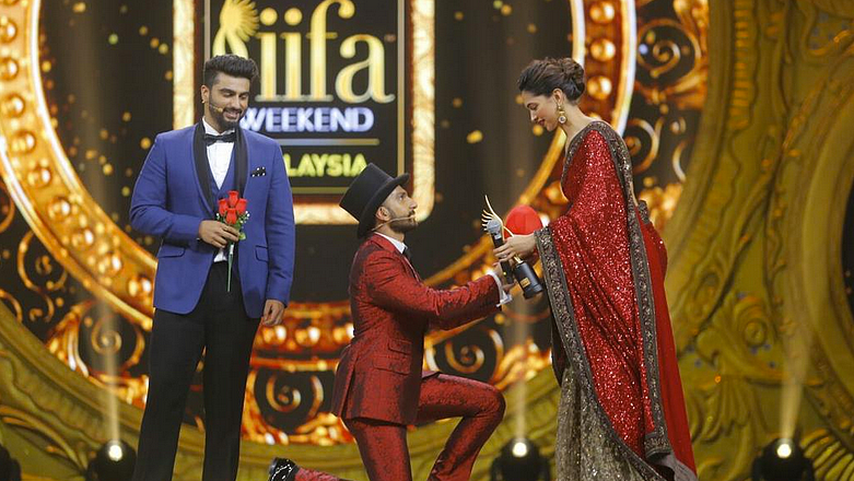 Arjun Kapoor looks on as Ranveer Singh goes down on his knees for Deepika Padukone at IIFA 2015.