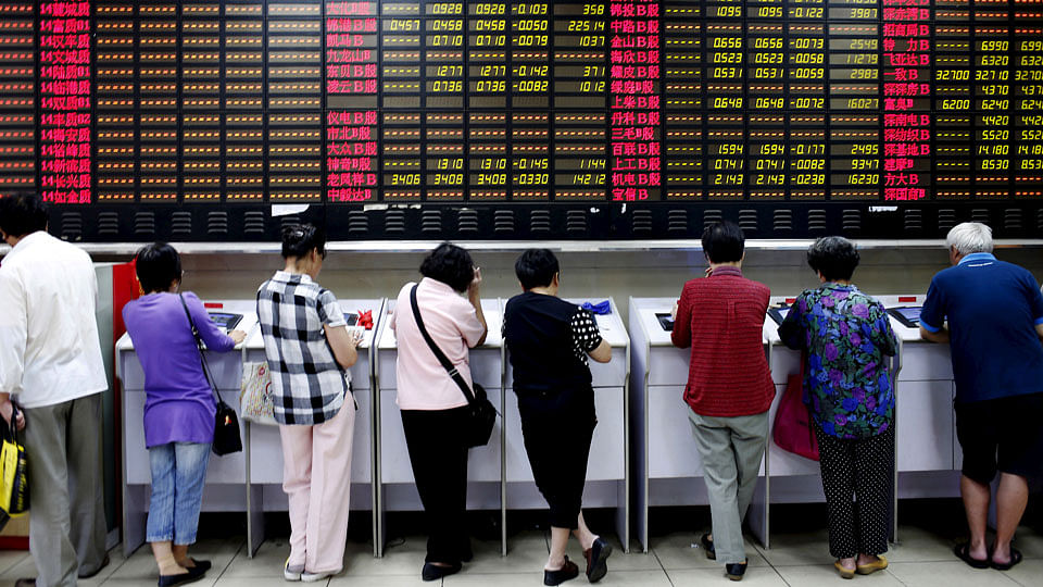 Investors look at computer screens showing stock information at a brokerage house in Shanghai. (Photo: Reuters)