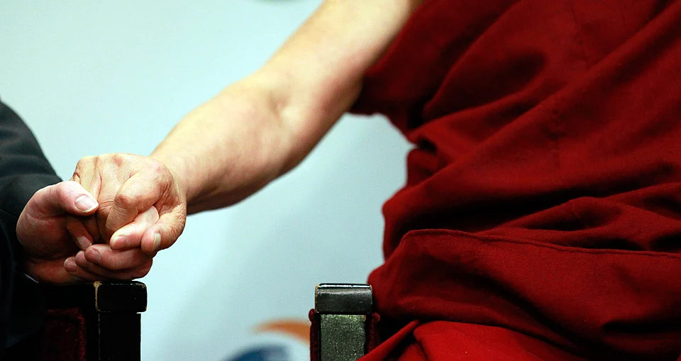 Tibetan spiritual leader the Dalai Lama (R), holds hands with Richard Moore, Director of the Children in Crossfire charity, during his visit to Londonderry. (Photo: Reuters)