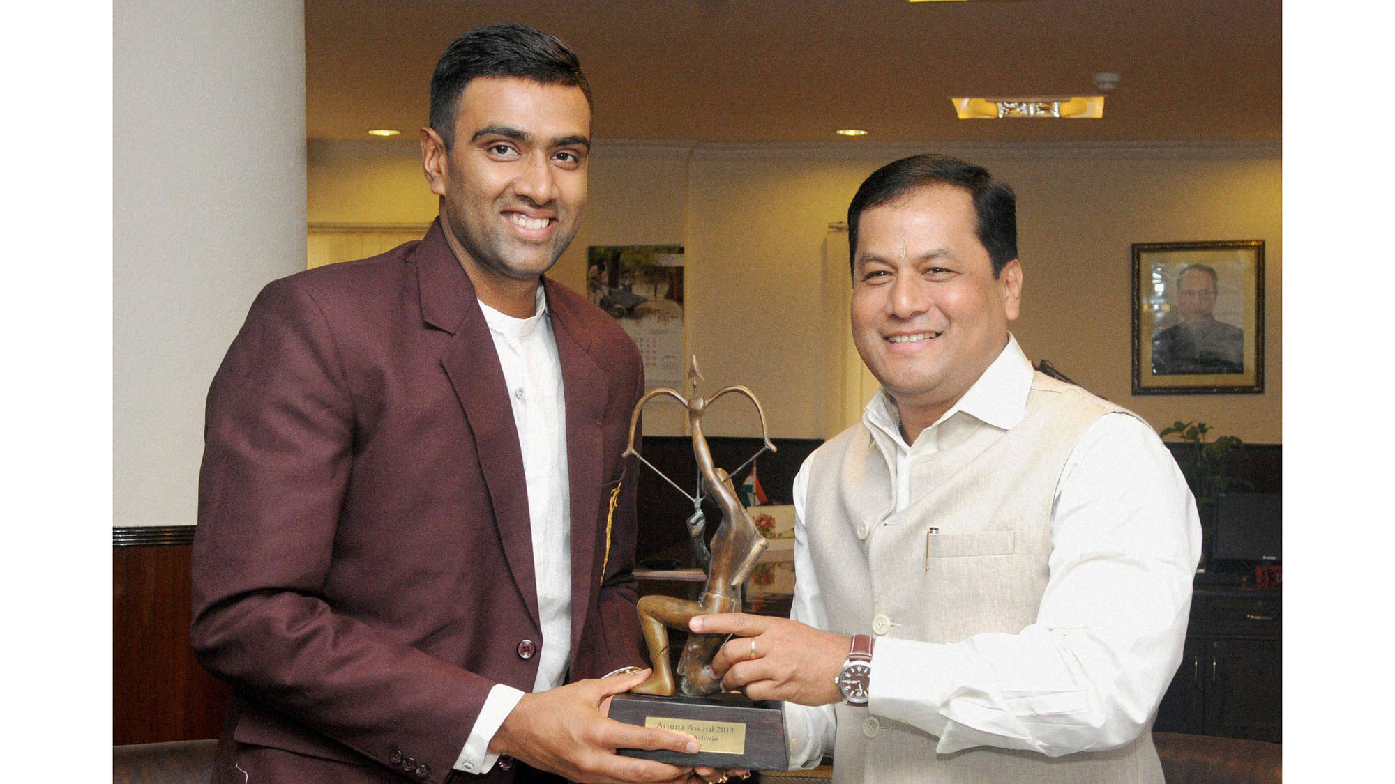 Sports Minister Sarbananda Sonowal honours off-spinner Ravichandran Ashwin with the Arjuna Award which was conferred on him last year, in New Delhi on Friday. (Photo: PTI)