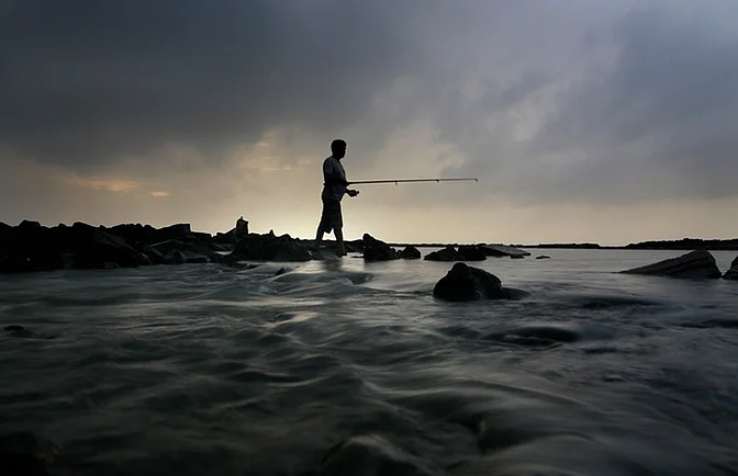 A fisher man catching fish in the Arabian Sea, Mumbai. 