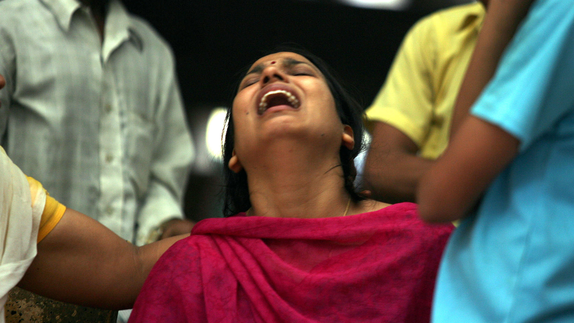 A woman mourns the death of her husband while waiting to receive his body from a mortuary. (Photo: Reuters)