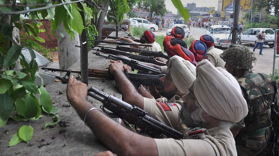 Police personnel take positions during an encounter with armed militants in Dinanagar town in Gurdaspur District of Punjab. (Photo: PTI)