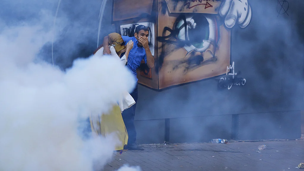 A couple running away from the teargas used by the police in Istanbul. (Photo: Reuters)