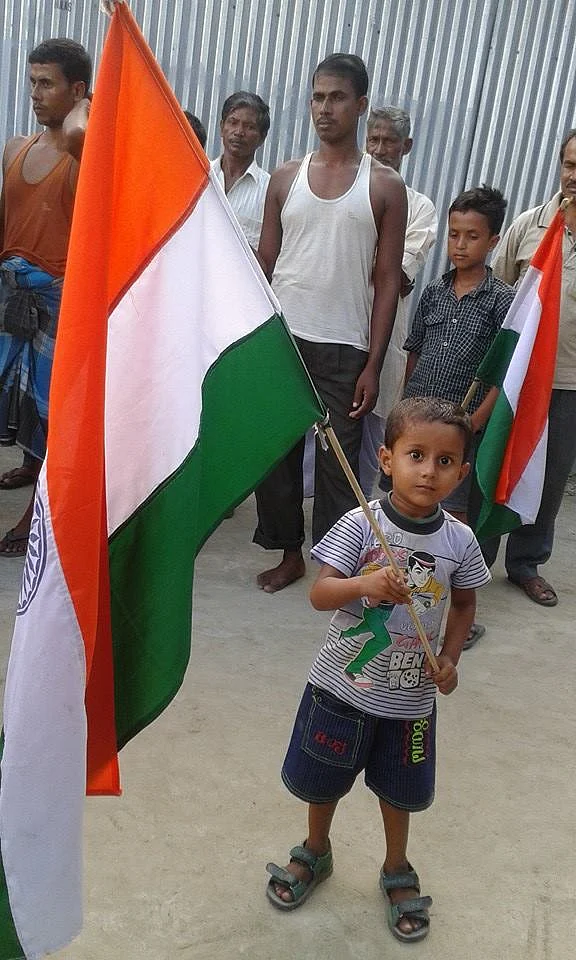 A little boy waves the tricolor as part of the enclaves celebration.