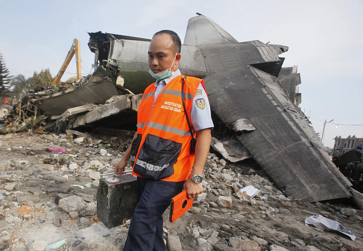 An investigator walks past the wreckage of the crashed air force transport plane in Medan in Indonesia. (Photo: AP)