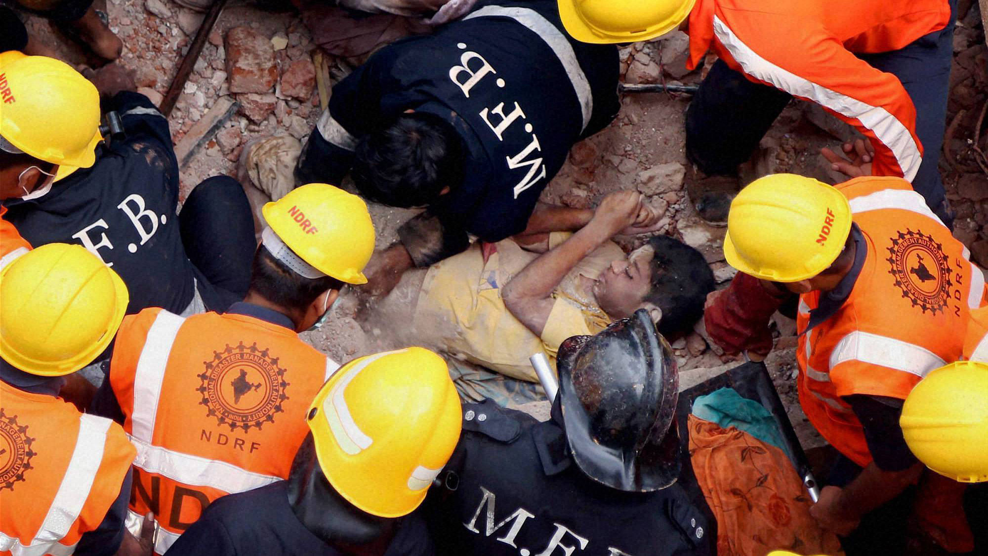 Rescue personnel save a person from the third&nbsp;floor of the collapsed building in Thane. (Photo: PTI)