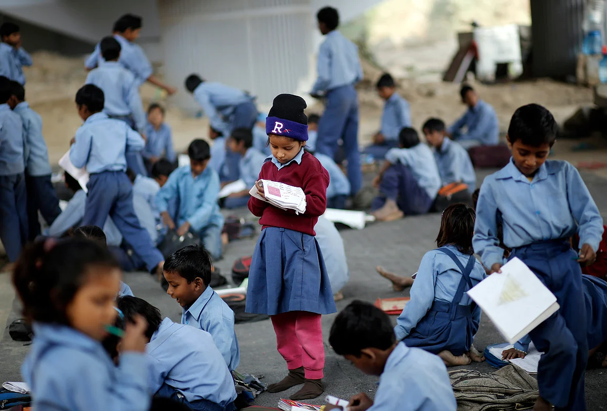 A schoolgirl reads from a textbook at an open-air school in New Delhi, November, 2014. (Photo: Reuters)