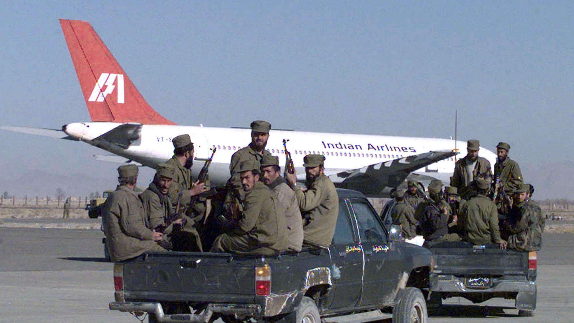 Armed soldiers from the Taliban Islamic militia race towards the hijacked Indian Airlines plane at Kandahar airport.
