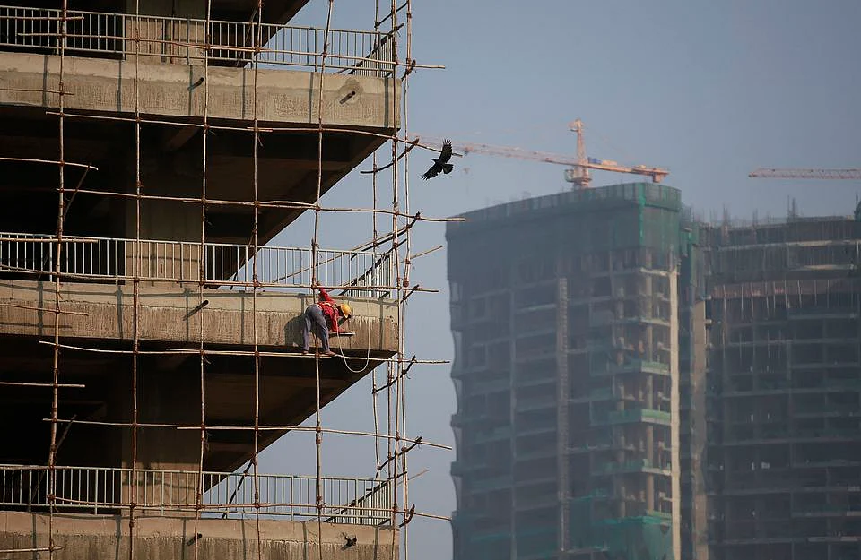 A labourer stands on wooden scaffolding as he works at the construction site of a commercial building in Mumbai’s central financial district January 16, 2015. (Photo: Reuters)
