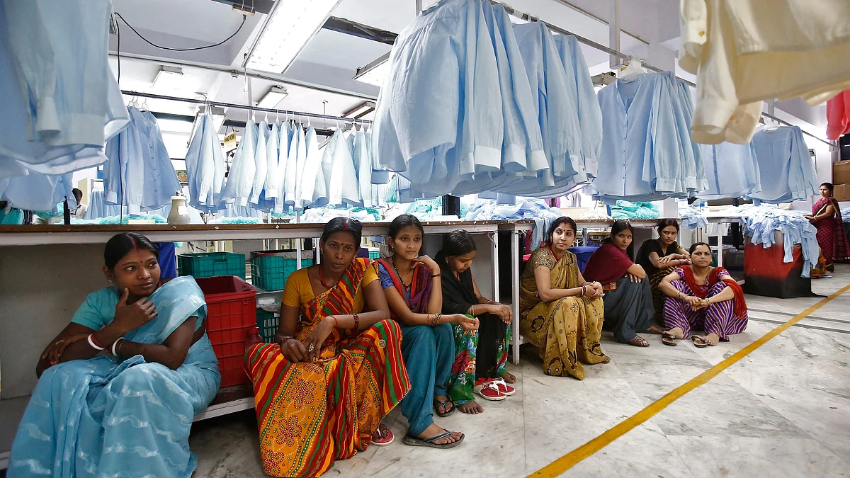 Employees sit during their lunch time inside a textile mill of Orient Craft Ltd. (Photo: Reuters)