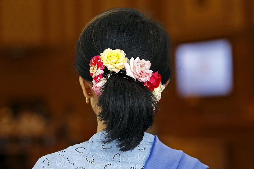 Myanmar’s pro-democracy leader Aung San Suu Kyi, wearing her trademark flowers in her hair, arrives for a session of parliament in Naypyidaw. (Photo: Reuters)