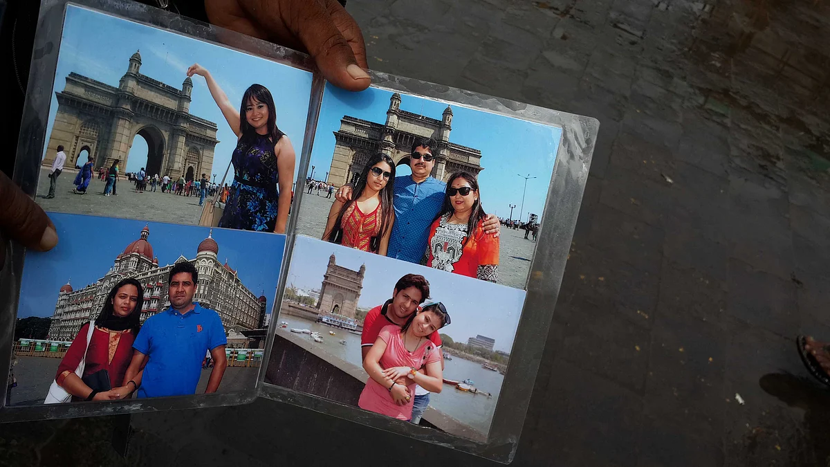 A photographer at the Gateway of India holds out his photo album (Photo: Mohit Khushalani)