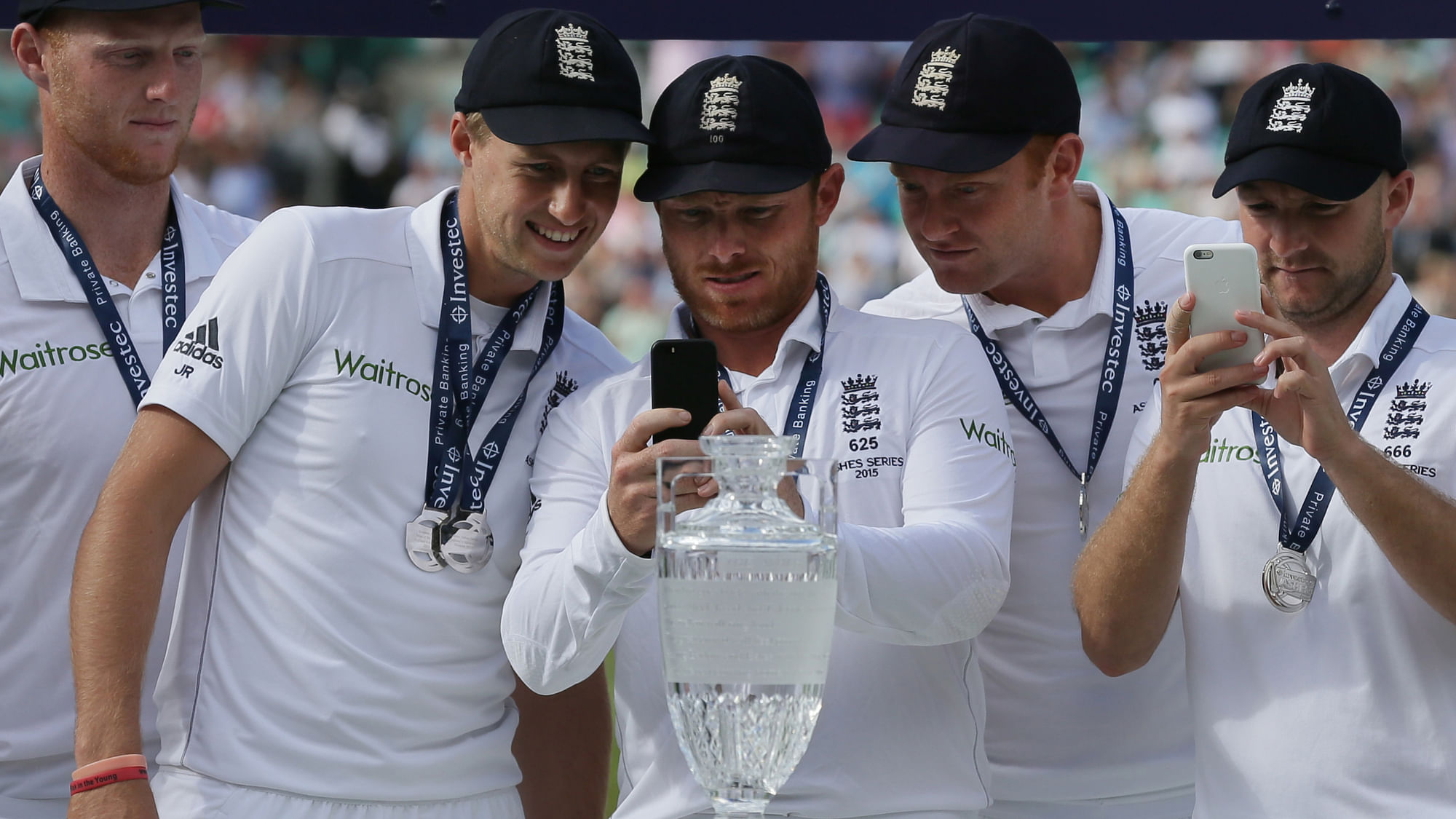 England’s Joe Root, second left, and teammate England’s Ian Bell, center, take pictures on their phones prior to a presentation ceremony on the fourth day of the fifth Ashes test.&nbsp;(Photo: AP)