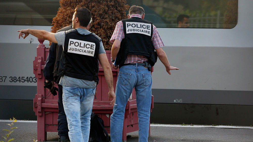 French Judicial Police officers stand near cartridges and a backpack. (Photo: Reuters)
