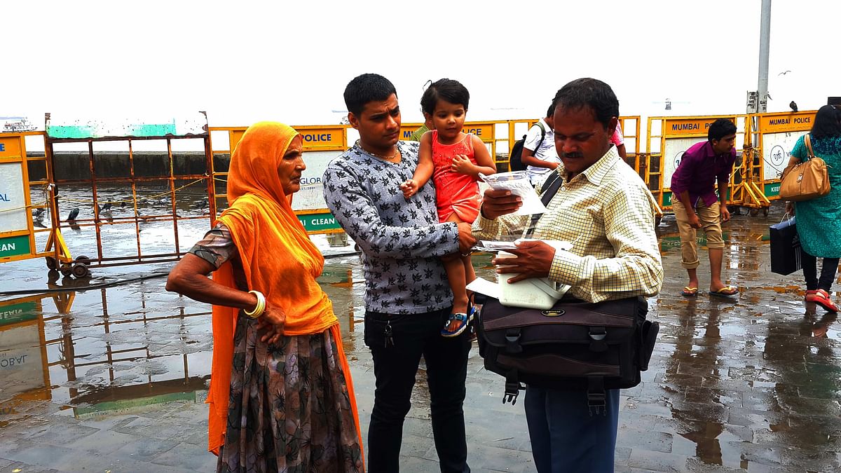 Photographer Dwijendra Singh gives out a print out of a photograph to this family (Photo: Twish Mukherjee)