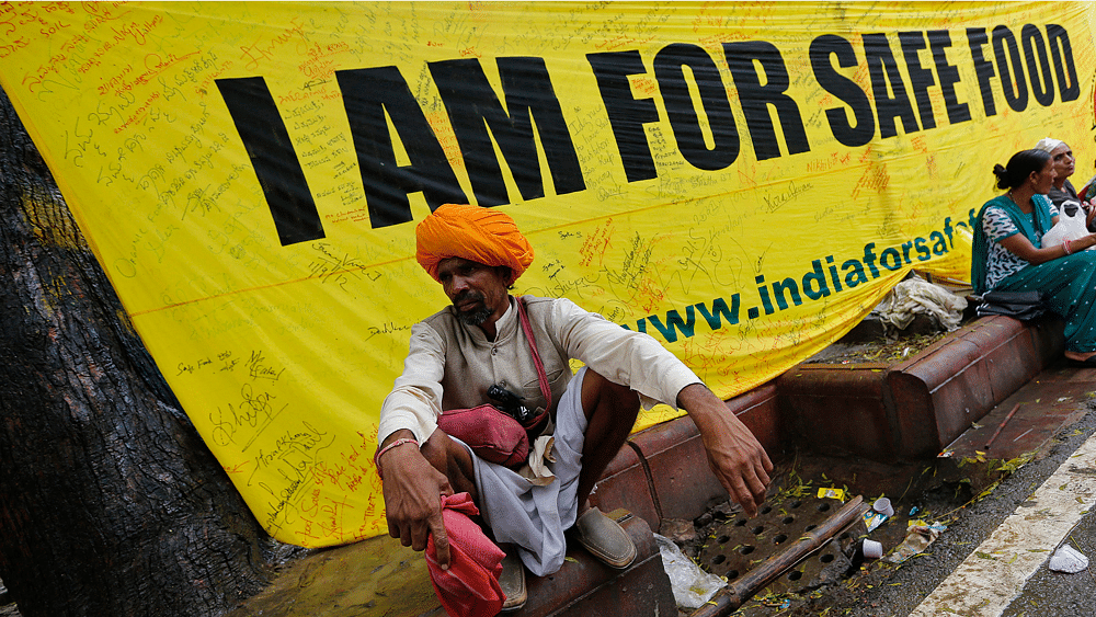 A farmer squats along a footpath near a banner during a day-long protest in New Delhi August 8, 2013.&nbsp;(Photo: Reuters)