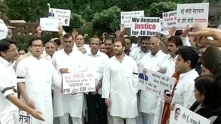 Congress workers protest near Gandhi statue outside Parliament against the government’s  silence in Vyapam scam.