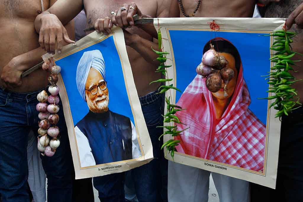 August 14, 2013: Protesters belonging to the BJP hold garlands of onions and green chillies around portraits of Prime Minister Manmohan Singh and Congress President Sonia Gandhi in Allahabad. (Photo: Reuters)