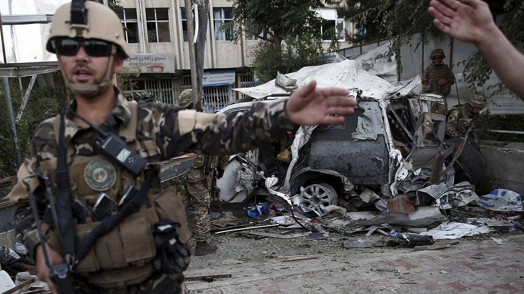 Members of Afghan security forces keep a watch in front of a damaged car that belongs to foreigners after a bomb blast in Kabul. Image used for representational purposes.&nbsp;