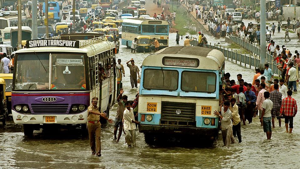 People push a bus through a flooded road in Bengaluru, October 24, 2005. (Photo: Reuters)
