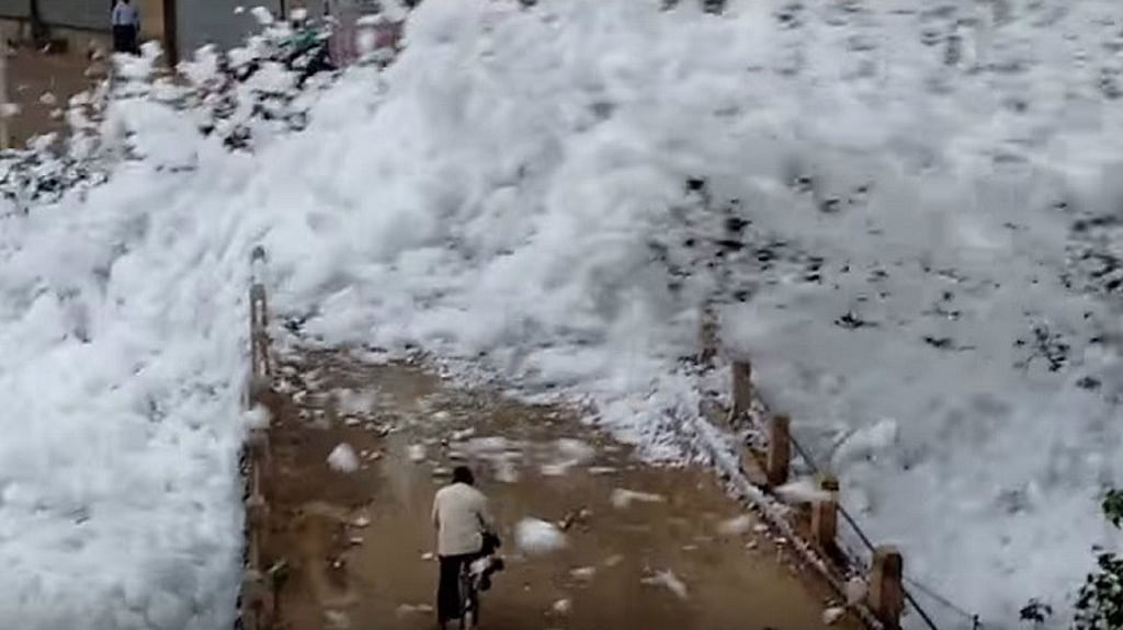 Toxic foam-shower from Bengaluru’s lake, flying over people on the road (Photo courtesy: The News Minute)