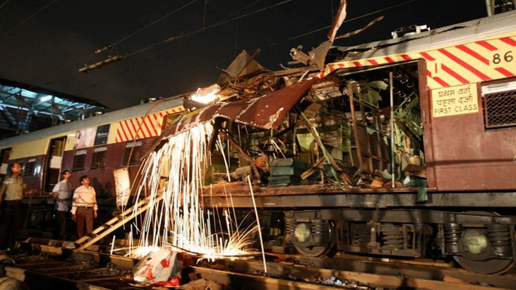 Workers cut a damaged part of the local train compartment hit by the blast. (Photo: Reuters)