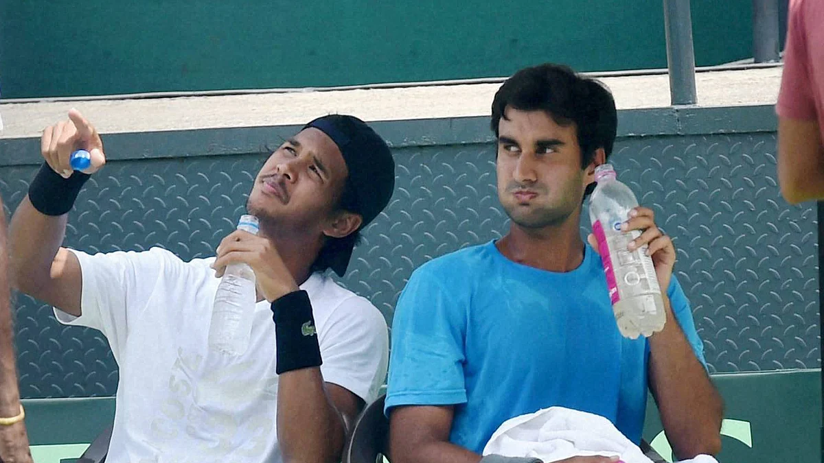 Yuki Bhambri and Somdev Devvarman take a break to cool off during a practice session at the Delhi Lawn Tennis Association Courts in New Delhi. (Photo: PTI)