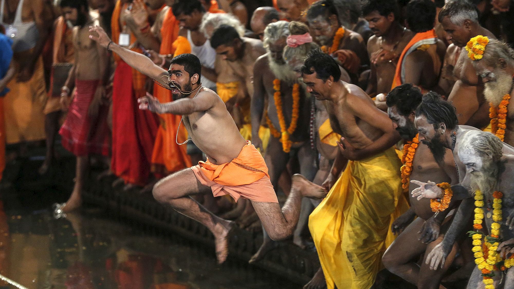 Sadhus jump in a holy pond during the first <i>Shahi Snan</i> (grand bath) at the <i>Kumbh Mela</i> in Trimbakeshwar.