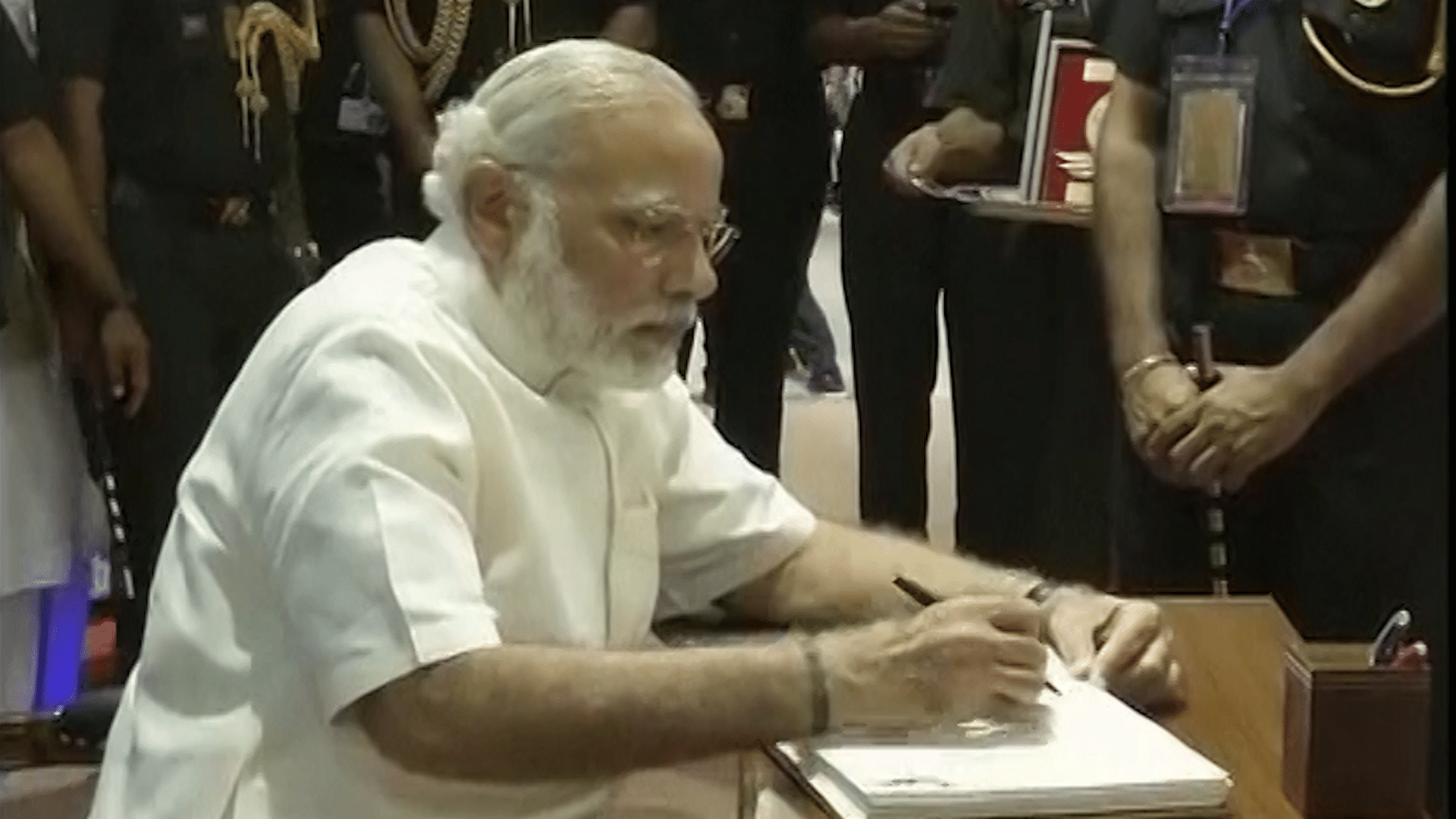 Prime Minister Narendra Modi writing down his thoughts in the visitor’s book at ‘Shauryanjali’ in New Delhi on Thursday. (Photo: ANI screengrab)