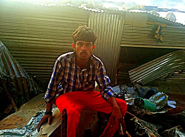 24-year old Sumith and his shed in the background. (Photo courtesy:<i>The News Minute</i>)