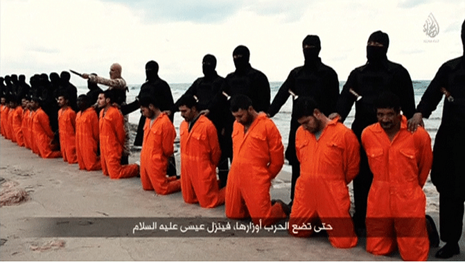  Men in orange jumpsuits purported to be Egyptian Christians held captive by the IS kneel in front of armed men along a beach said to be near Tripoli on 15 February 2015. (Photo: Reuters)