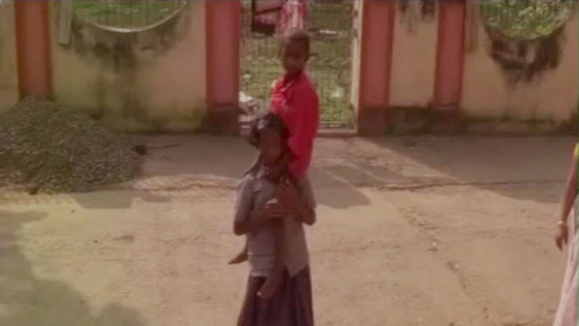 Malti Tudu, who is just 11 years old carries her younger brother on her shoulders in Godda, Jharkhand. (Photo: ANI screengrab)