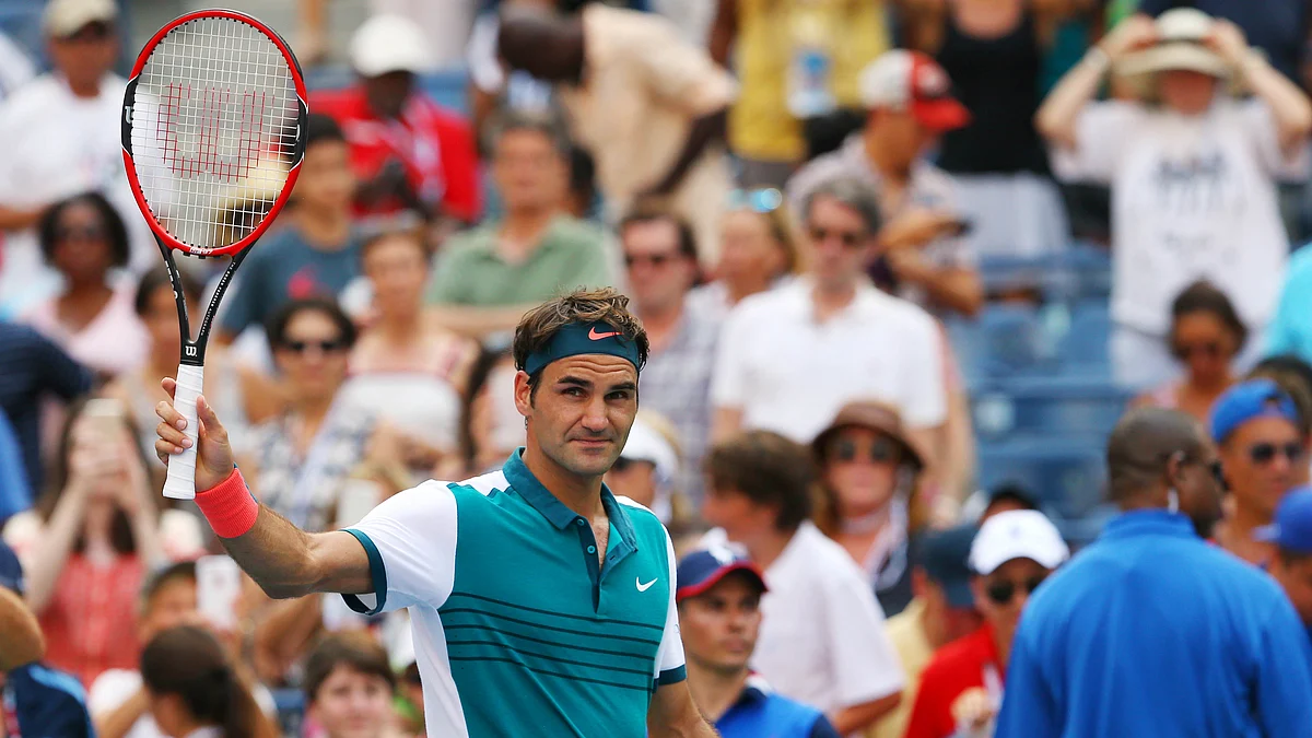 Roger Federer raises his racquet after winning against John Isner in the fourth round of the US Open. (Photo: Reuters) 
