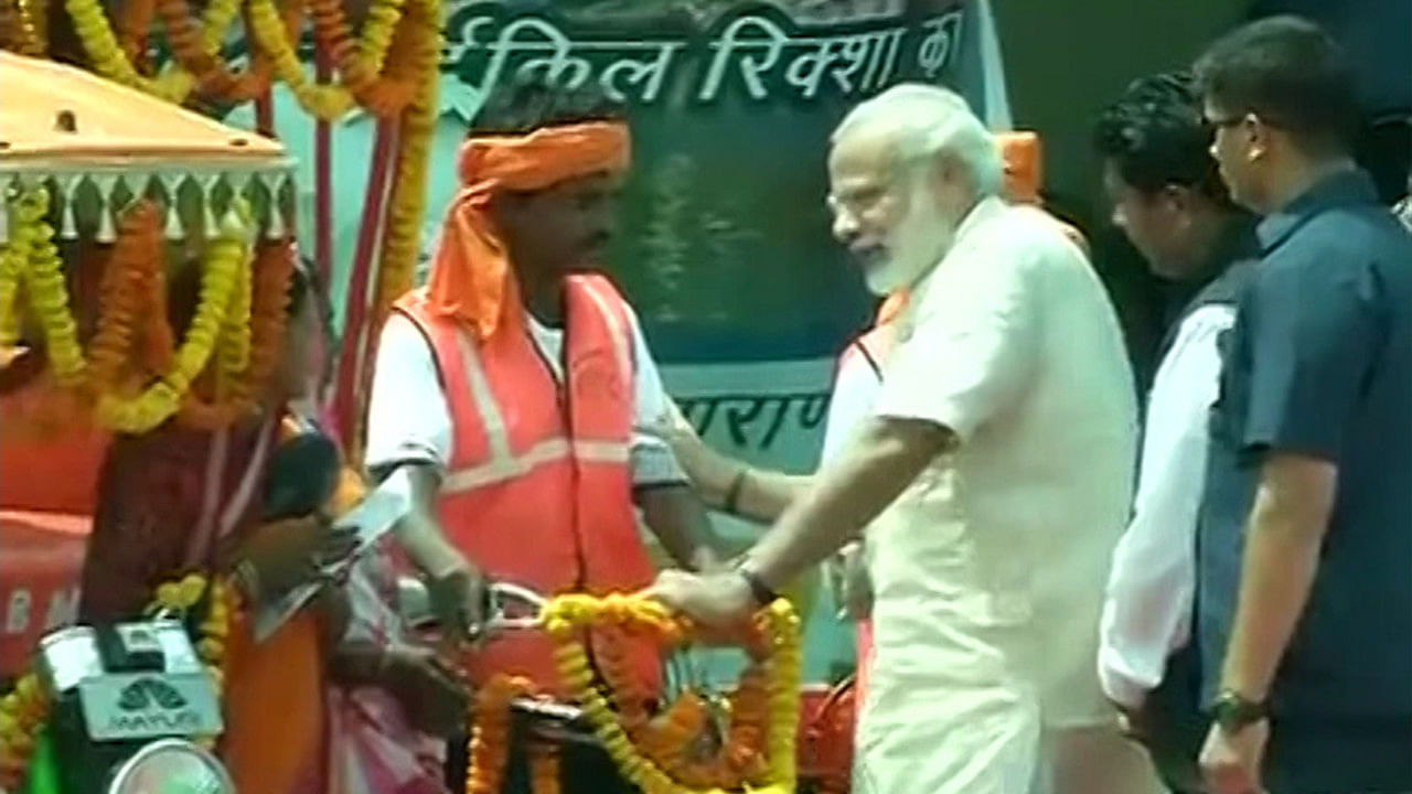 Prime Minister Narendra Modi distributed e-rickshaws and RuPay debit cards to beneficiaries at an event in Varanasi today. (Photo: ANI screengrab)