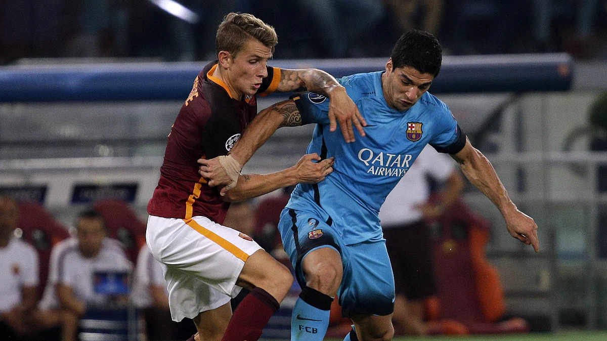 Luis Suarez fights for the ball with AS Roma’s Lucas Digneduring their Champions League group match. (Photo: Reuters)