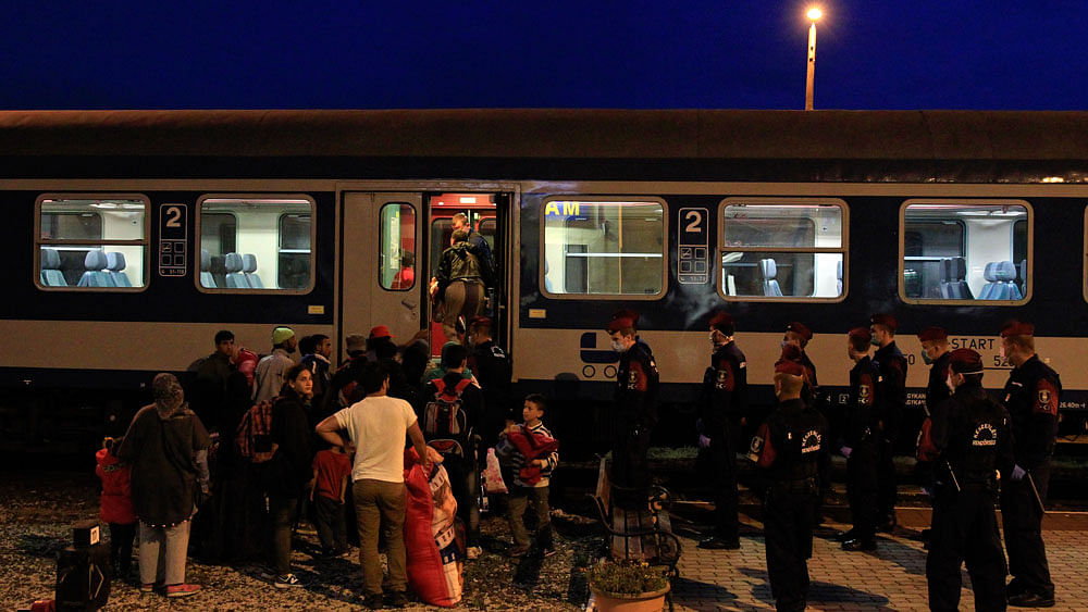 Migrants enter a train at a train station in Magyarboly in Hungary. (Photo: Reuters)