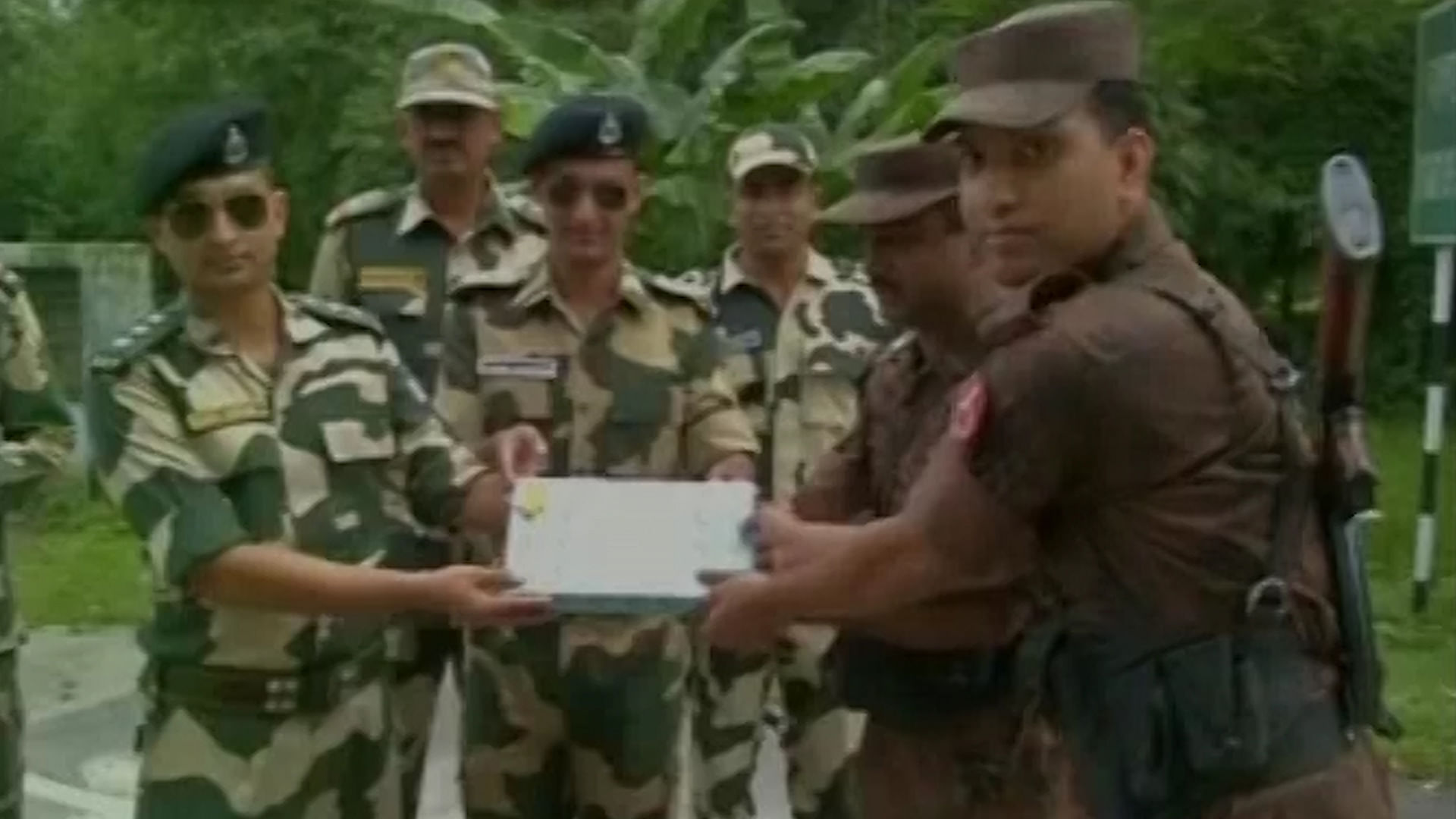 BSF and BGB troops exchanging sweets at Phulbari border in Jalpaiguri district, West Bengal on the occasion of Eid, on Friday. (Photo: ANI screengrab)