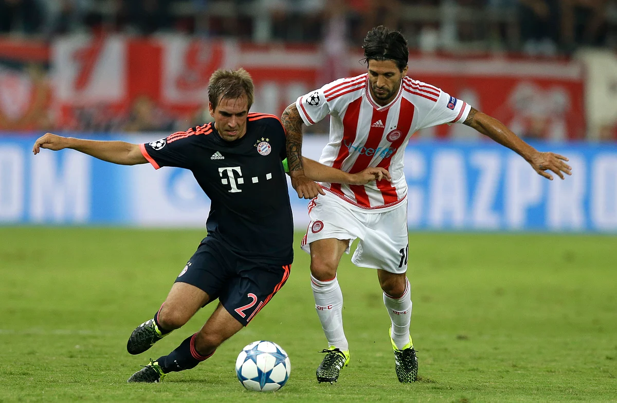Bayern’s Philipp Lahm, left, and Olympiakos’ Alejandro Dominguez challenge for the ball during their Champions League Group match. (Photo: AP)