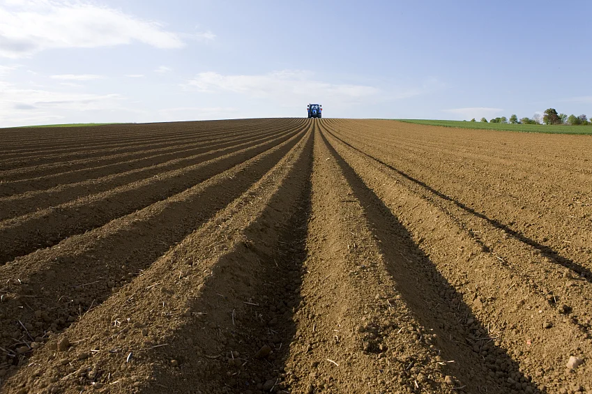 Ploughed field with tractor in distance. (Photo: iStockphoto)
