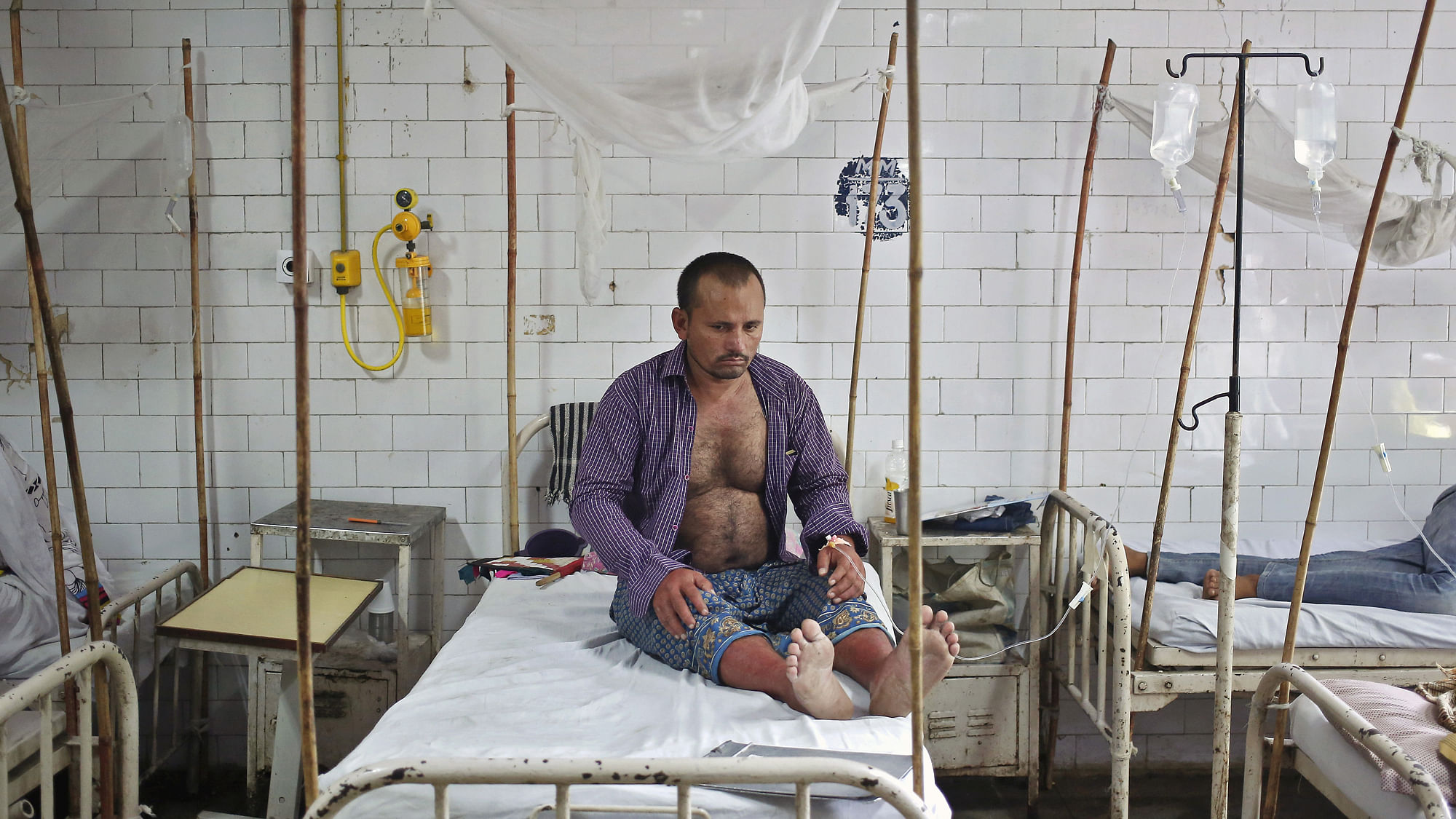  A patient awaits routine check-up as he sits under a mosquito net inside a dengue ward of a government hospital in New Delhi. (Photo: Reuters) 