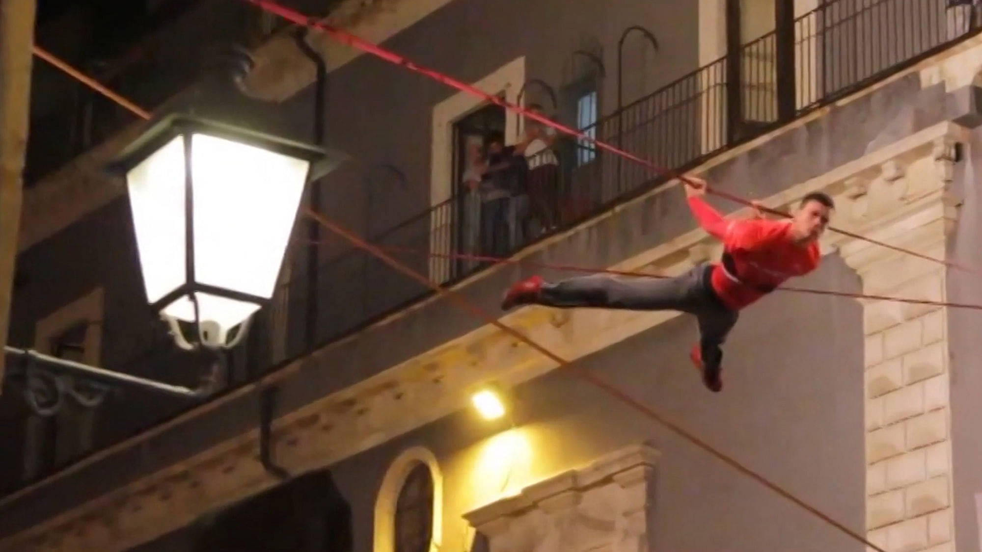 Acrobats slacklining across balconies in Italy. (Photo: AP screengrab)