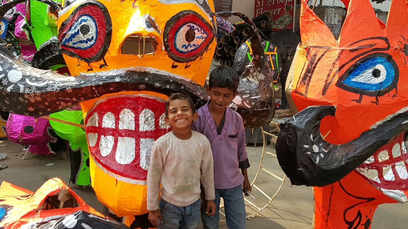 Smile like Ravan for the camera? The kids who help their dad make the massive heads for Ramlila happily oblige. (Photo: <b>The Quint)</b>