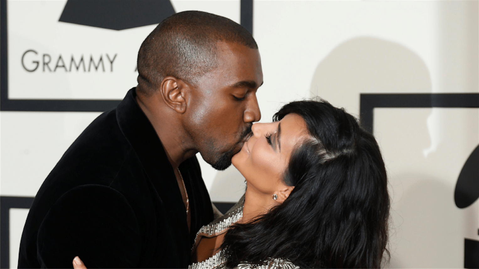 Kayne West and Kim Kardashian kiss for the shutterbugs at a Grammy event (Photo: Reuters)