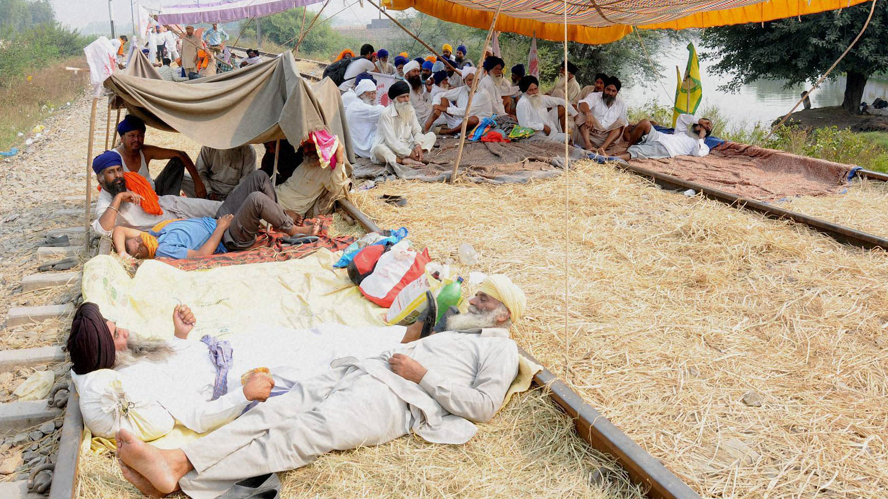 Farmers resting  on rail tracks near Amrisar on the fourth day of their rail roko agitation demanding  compensation to cotton growers for their crop loss, October 10, 2015. (Photo: PTI)