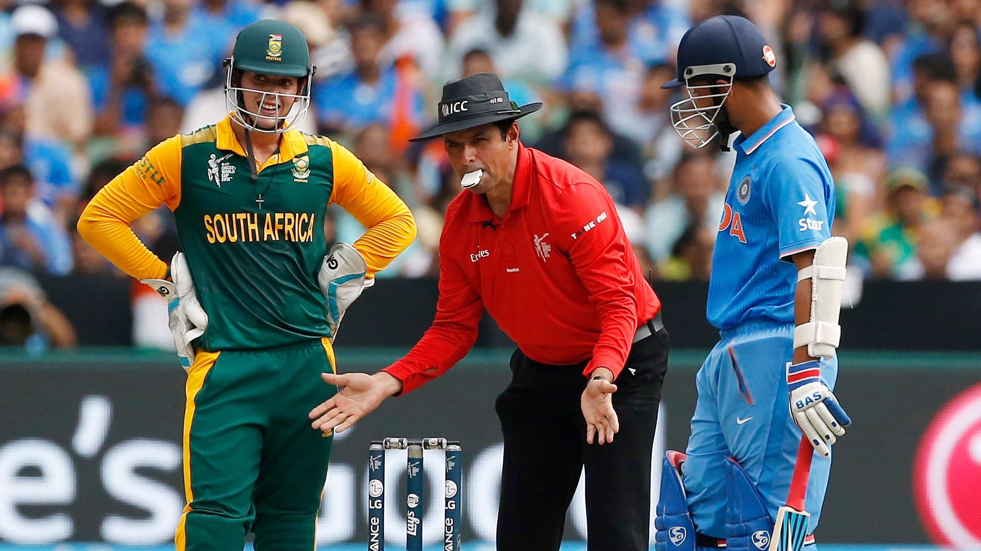South African wicketkeeper Quinton de Kockas (left) and India’s Ajinkya Rahane (right) watch as umpire Aleem Dar sets the stumps during their ICC Cricket World Cup clash. (Photo: Reuters)