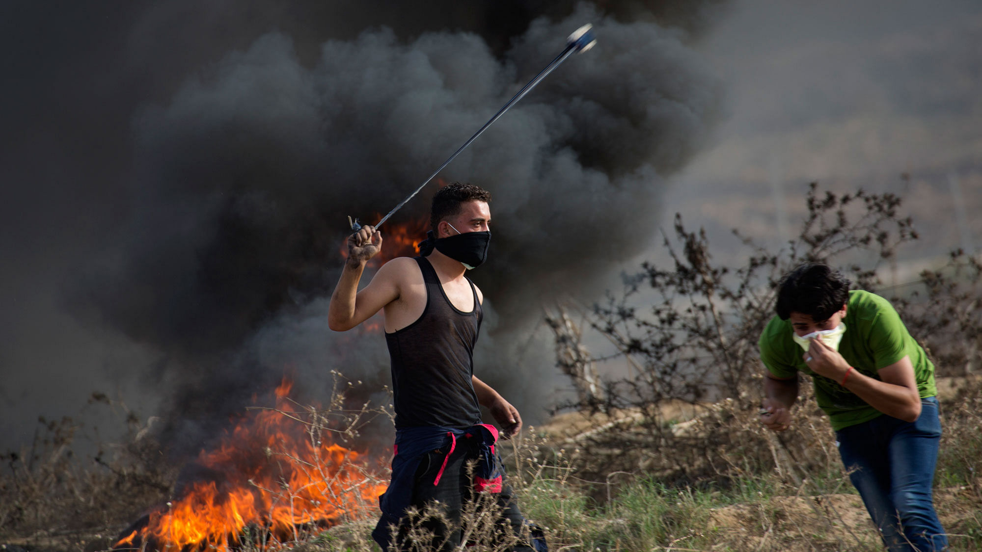 A Palestinian protester hurling stones at Israeli soldiers near the Israeli border with Gaza.&nbsp;